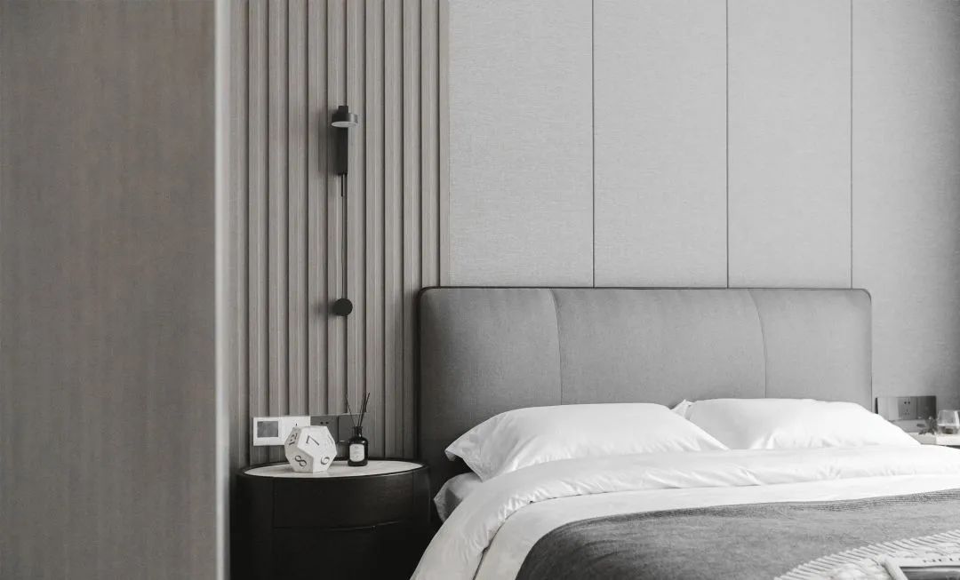 推开客厅隐藏的房门,父母房通过竖条格栅木饰面搭配灰色硬包做床背景